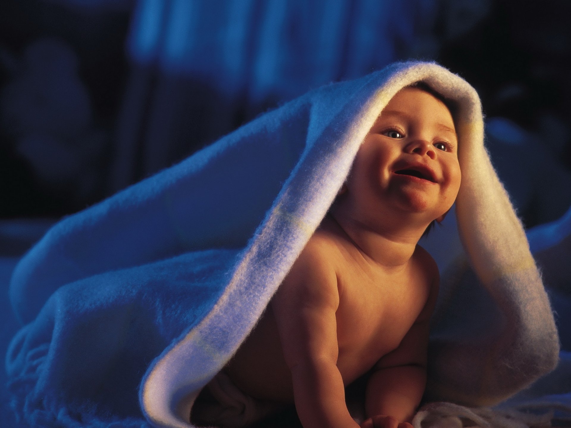 The charming baby is happy and happy in his mother's bed