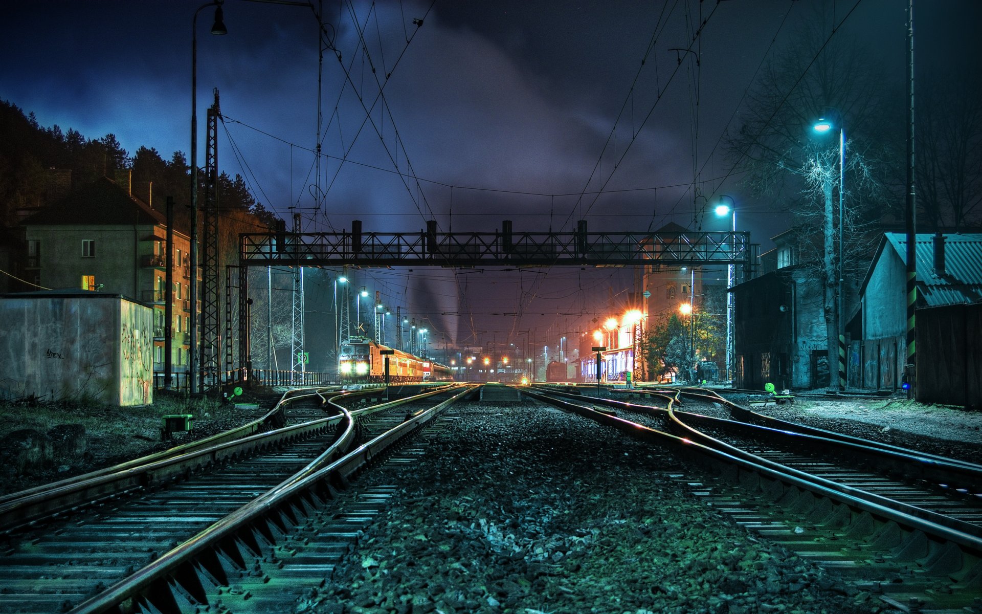 Railway at night between small houses