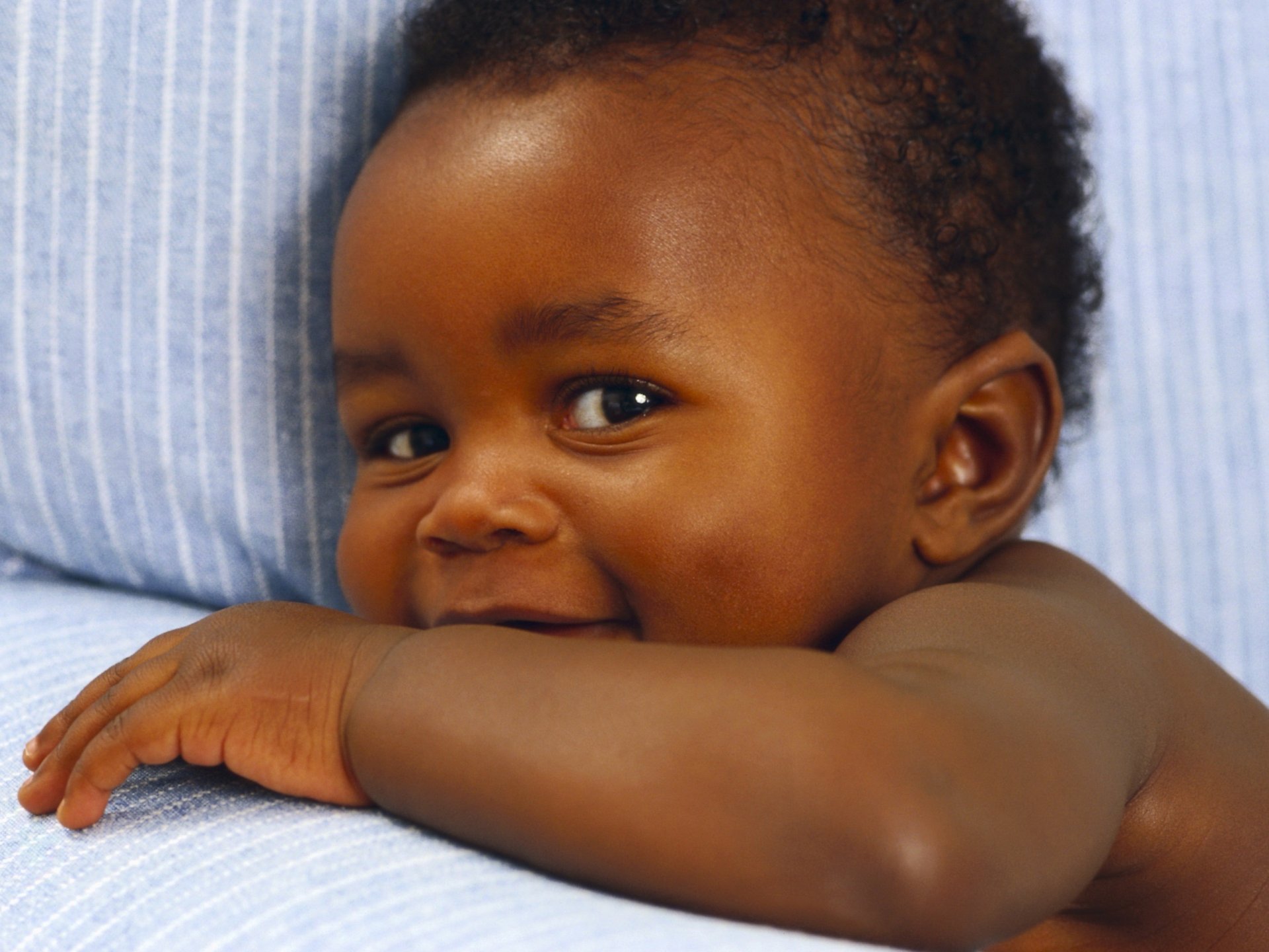 A small child with beautiful eyes smiles