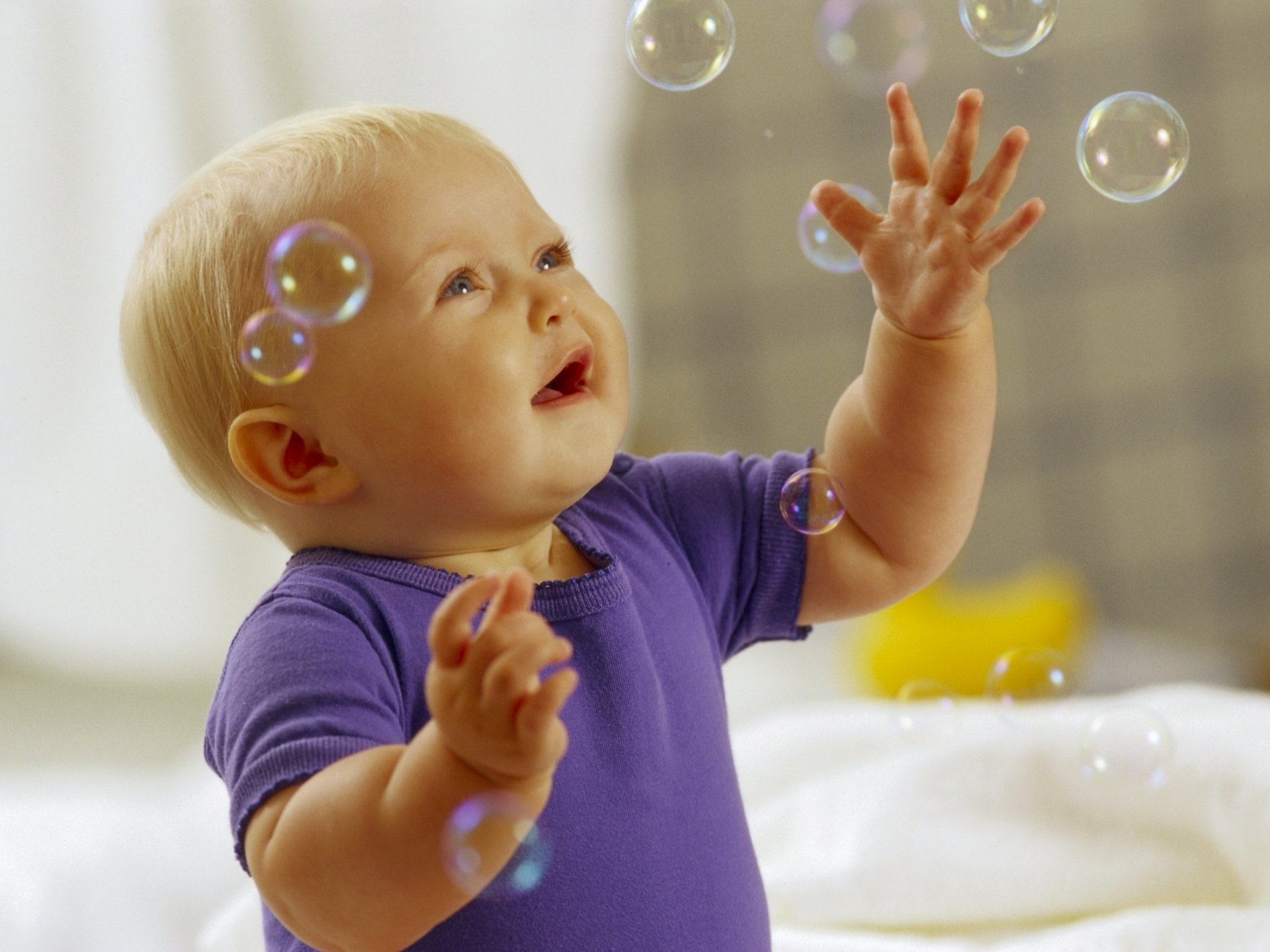 A small child catches soap bubbles