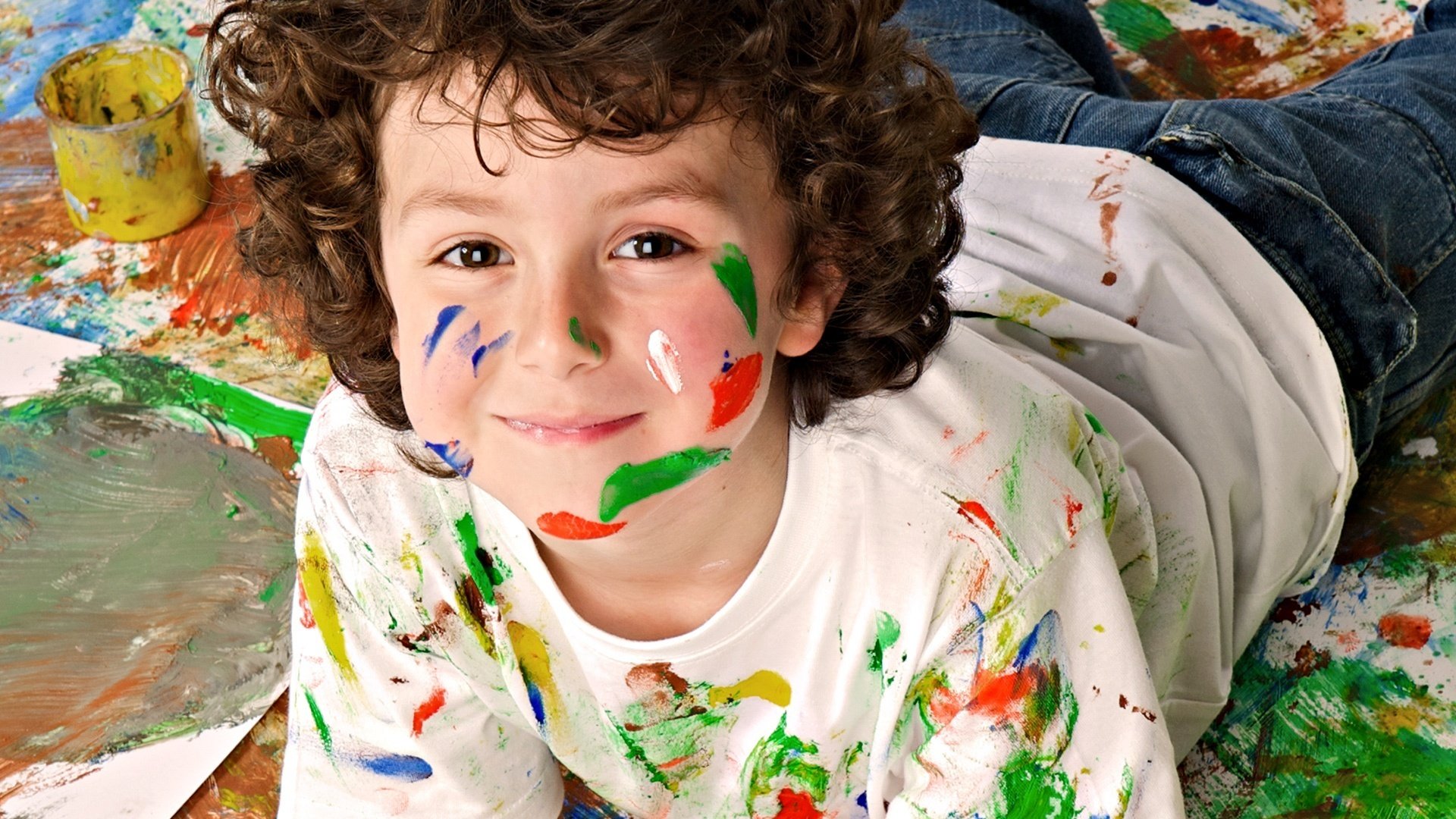 Curly-haired boy in paint as an artist
