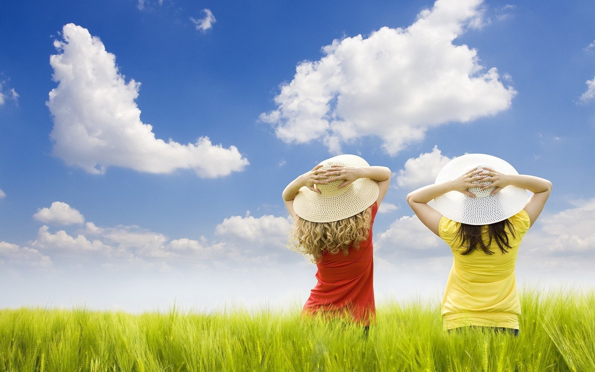 Girls in straw hats on a sunny meadow