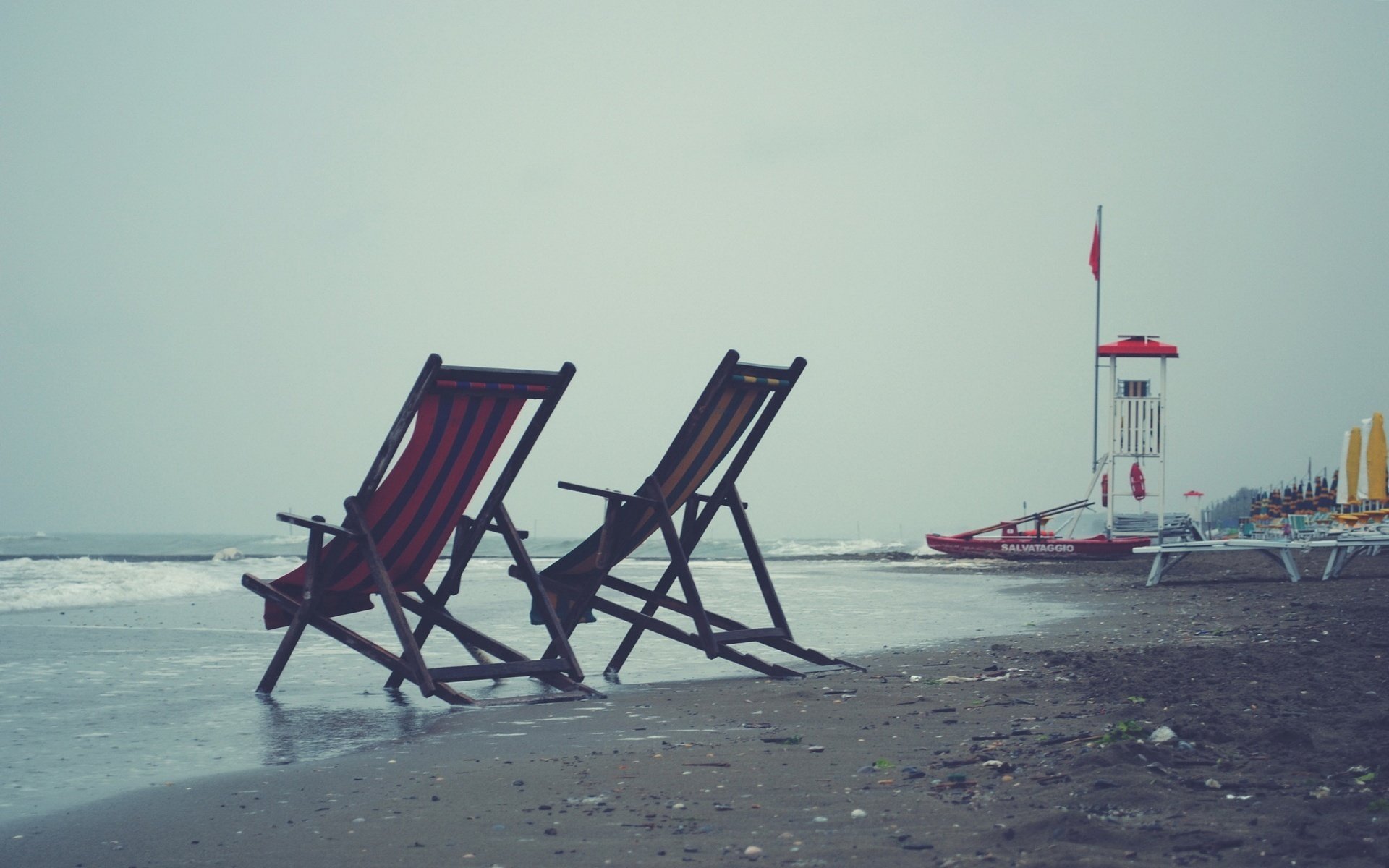Deck chairs on a gray cloudy beach