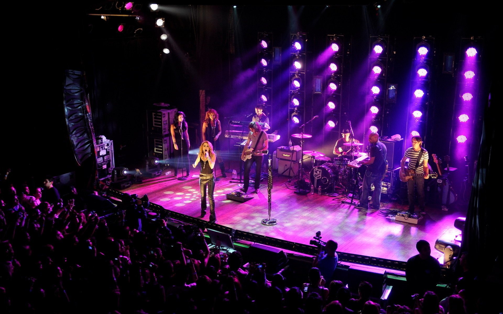 Performing on stage under pink spotlights