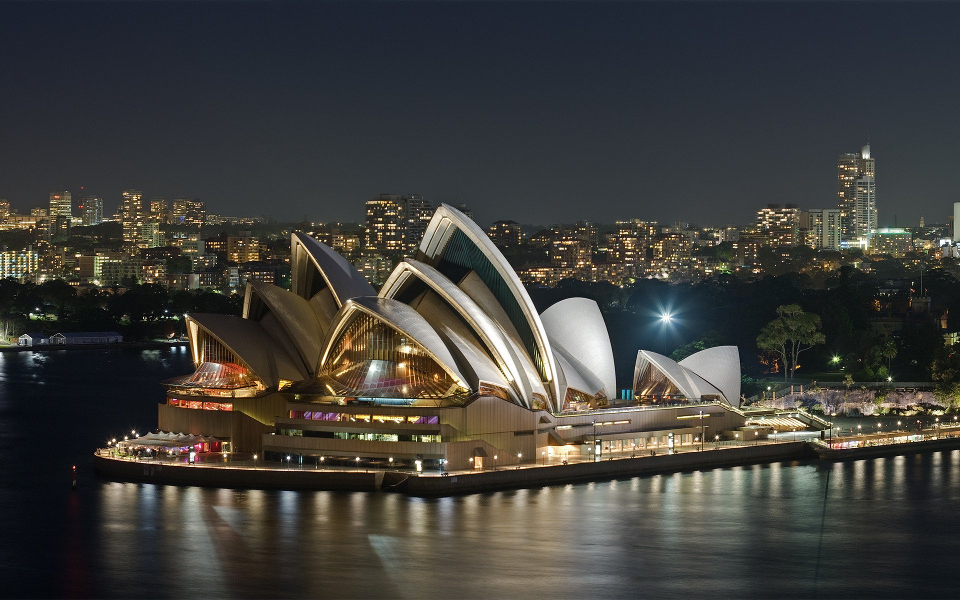 A unique opera house among the evening lights of Australia
