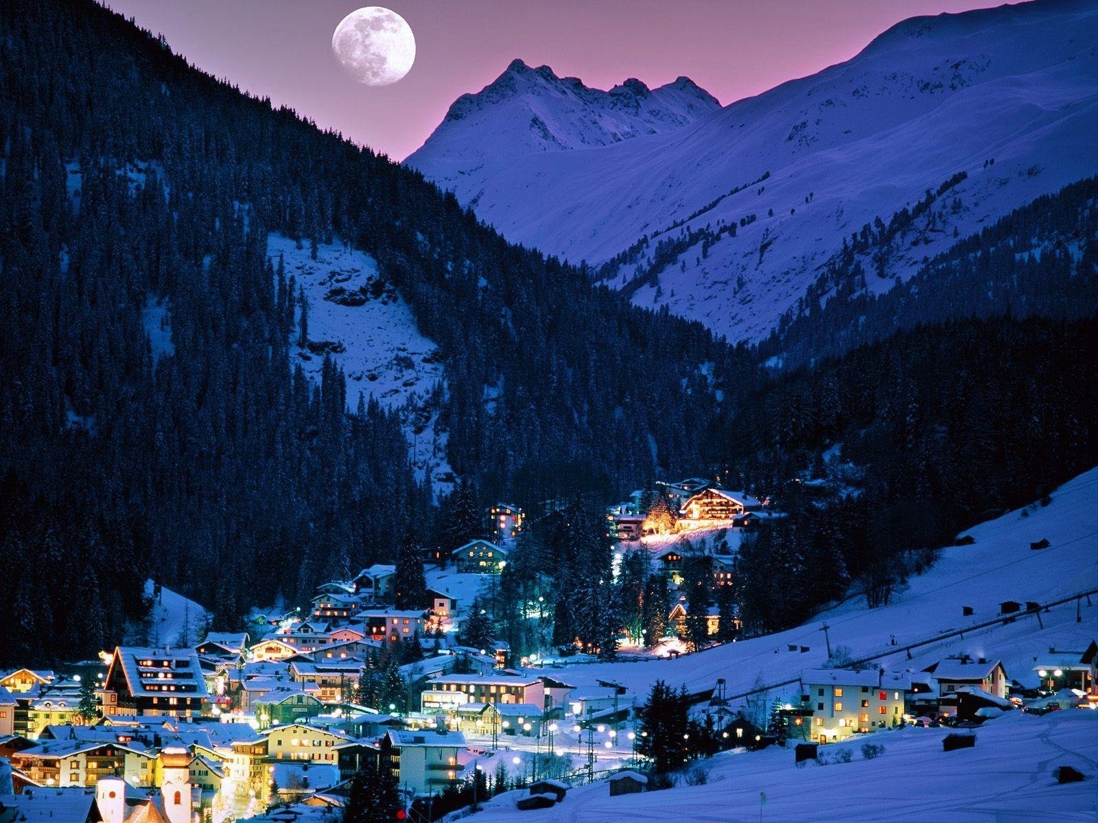 Winter evening in a village under the moon