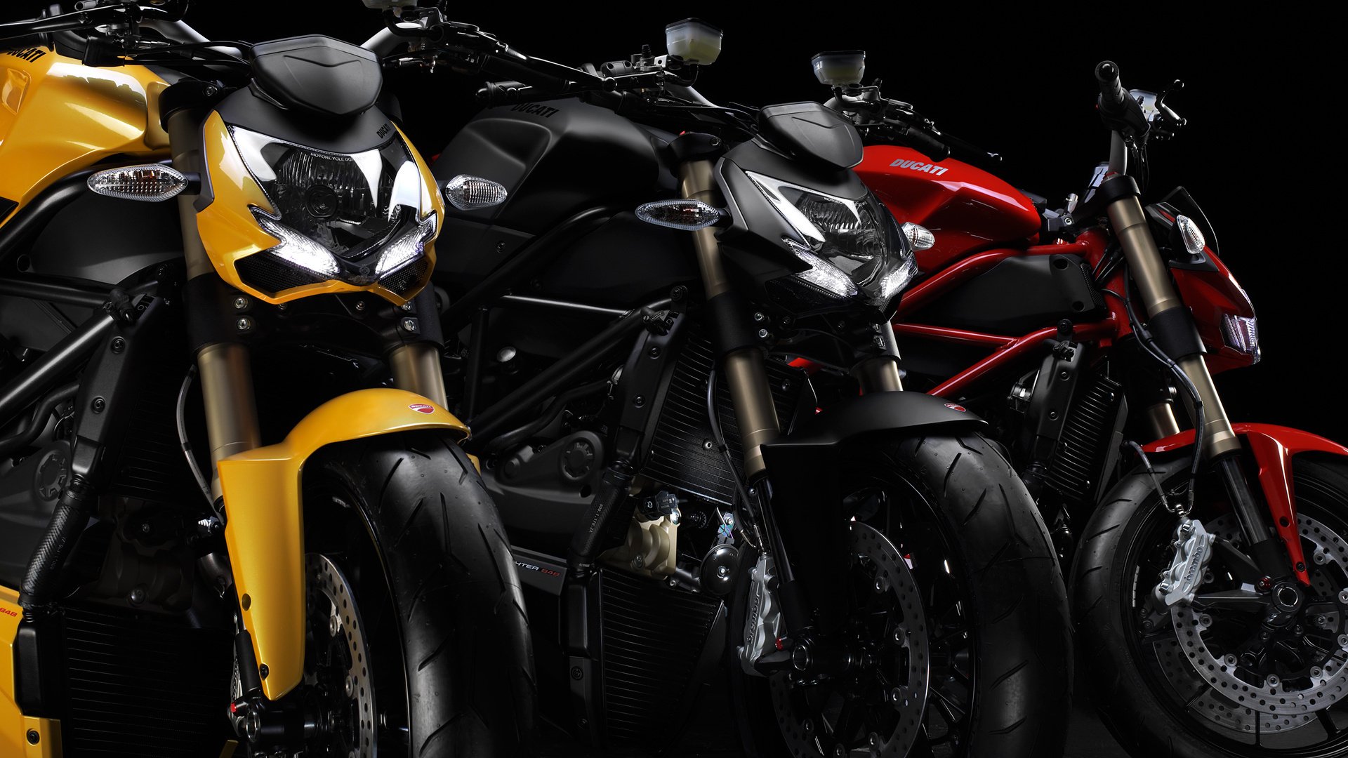 Yellow black and red ducati streetfighter motorcycles stand in a row