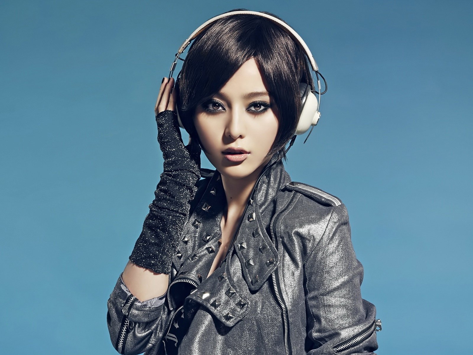 A young Asian woman in a leather jacket and headphones