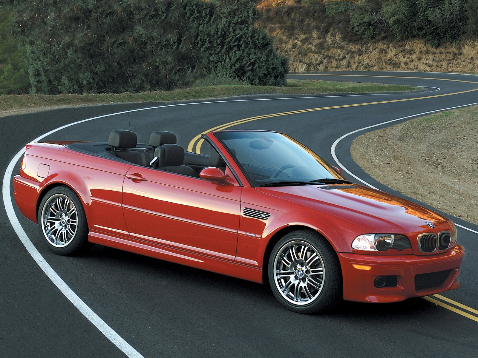 Red bmw e46 convertible on a winding road