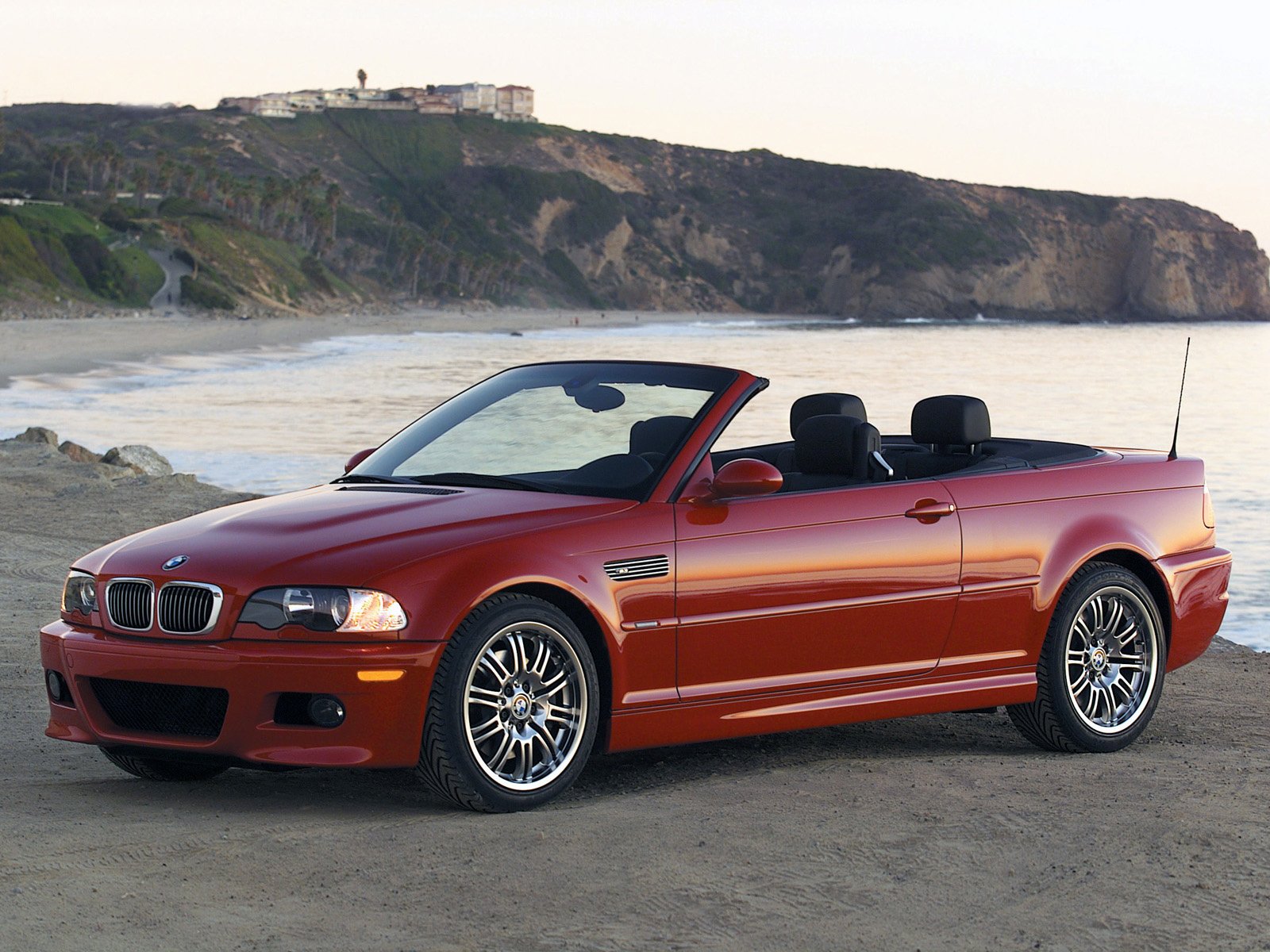 Red bmw e46 convertible on the seashore in profile