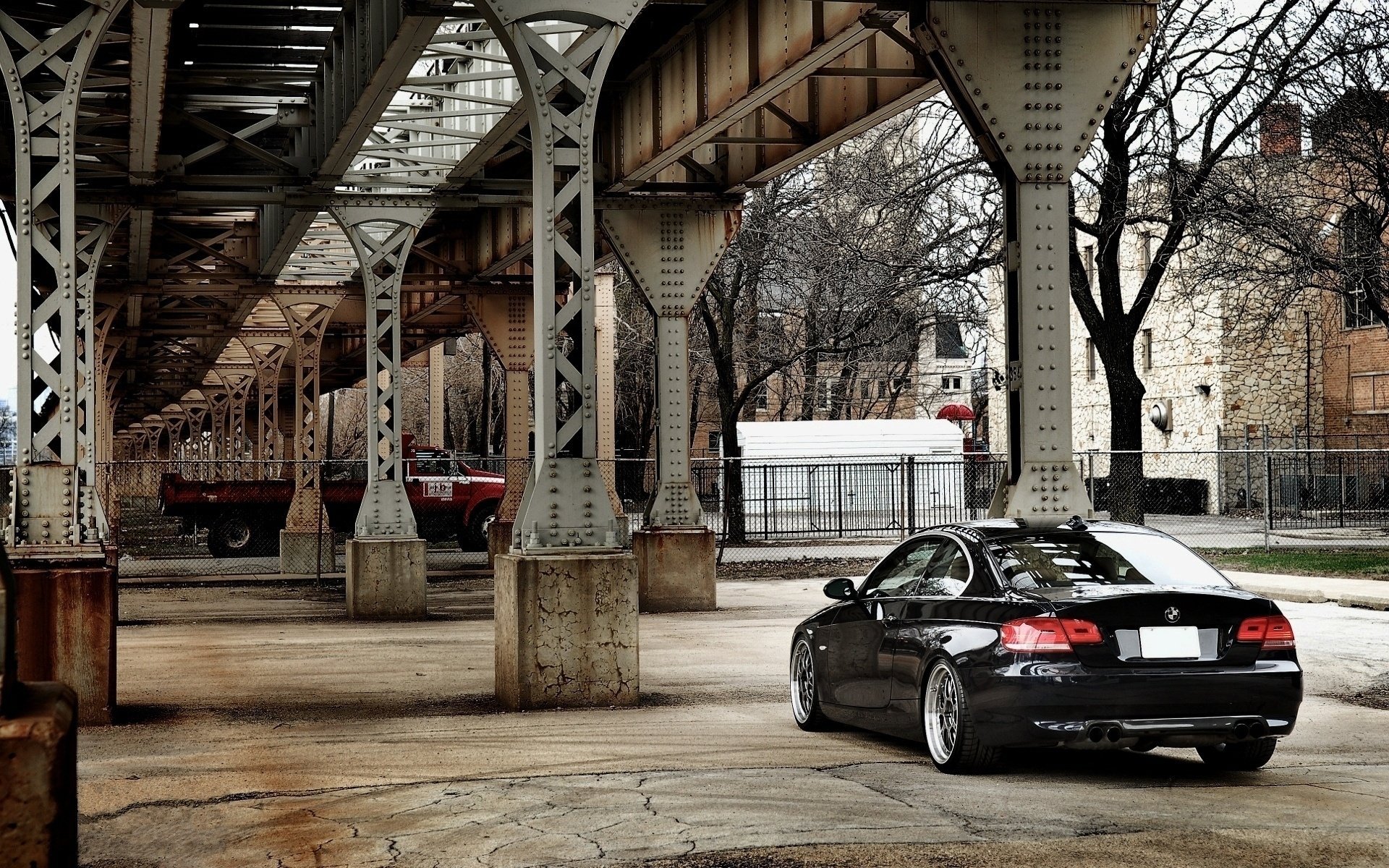 Black passenger car under the iron bridge