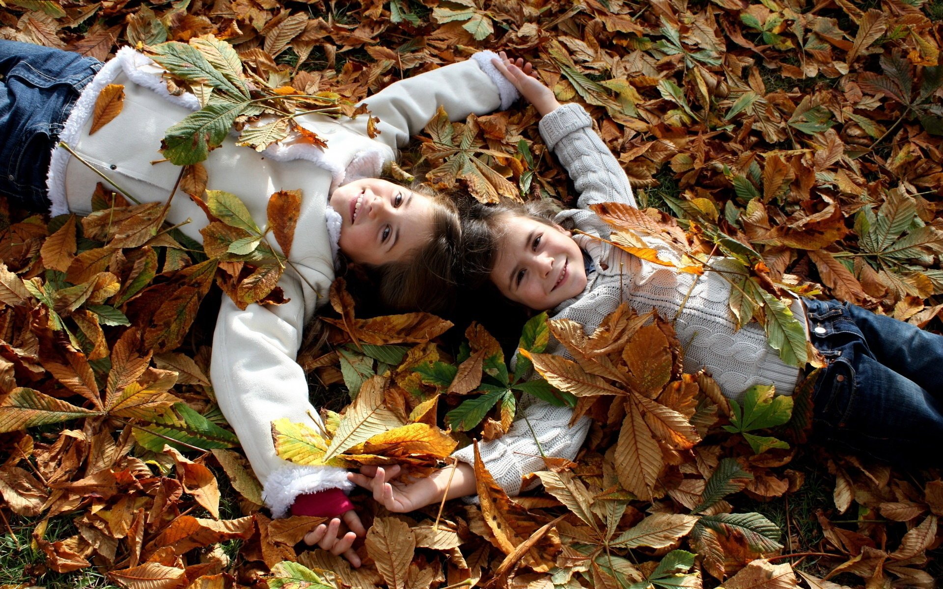 Two girls in autumn leaves