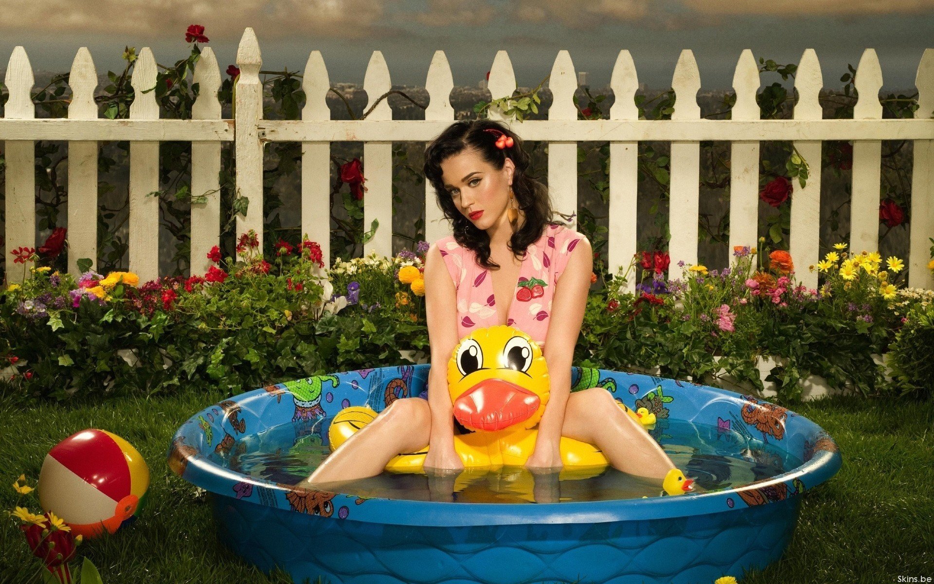 A girl in a mini-pool on a yellow duck