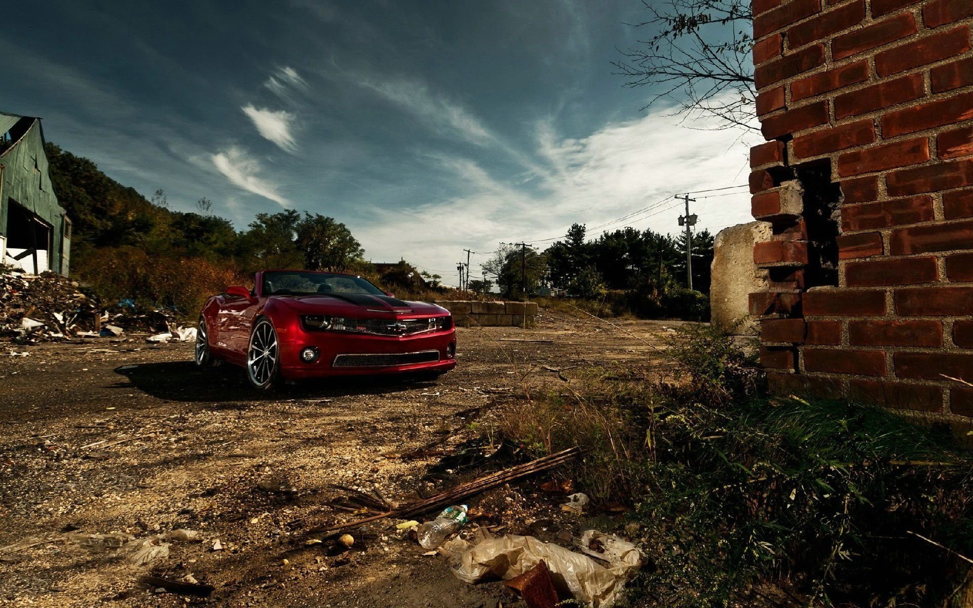 Red convertible and red bricks on a background of clouds