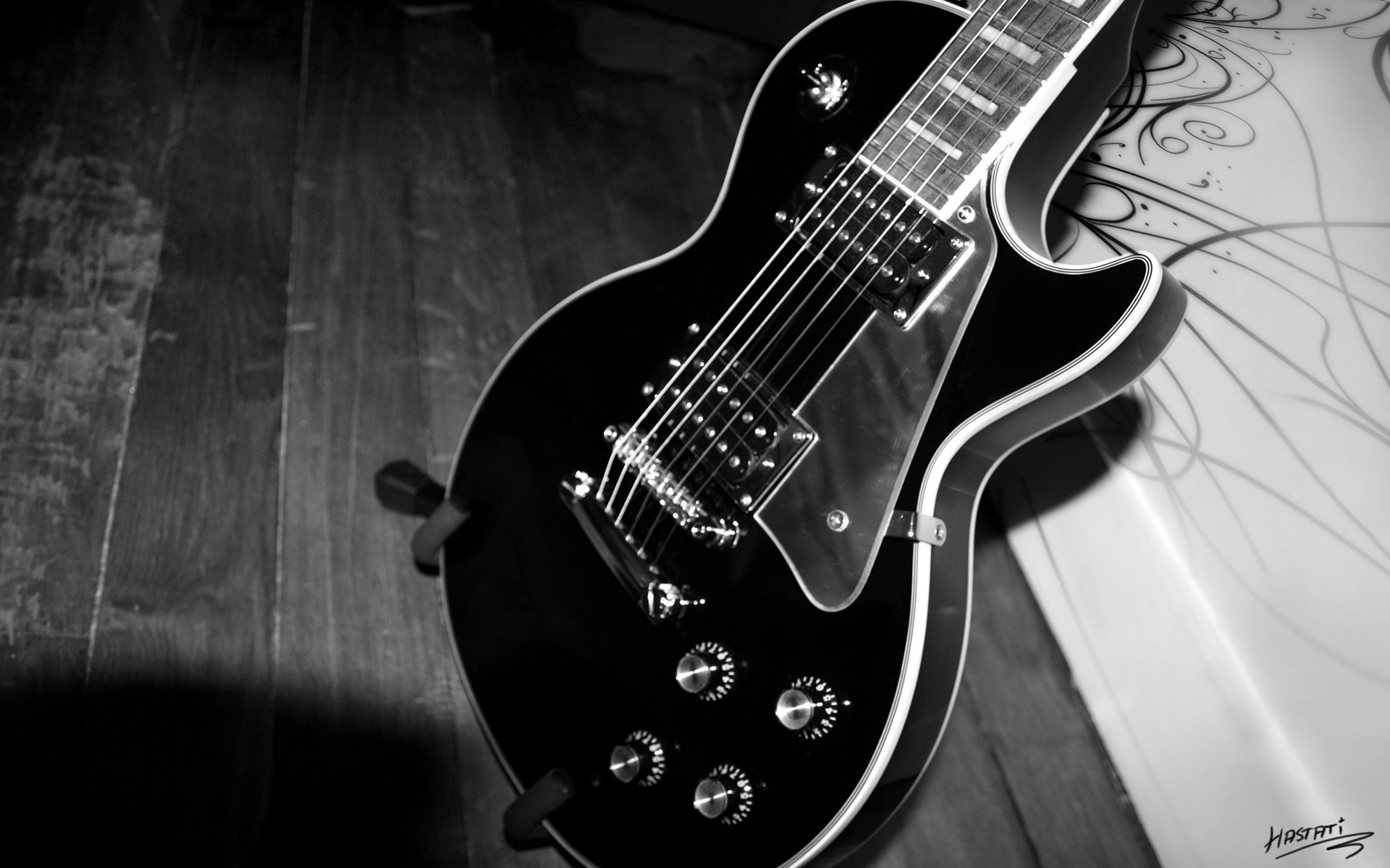 The electric guitar is black. Guitar on a black and white background