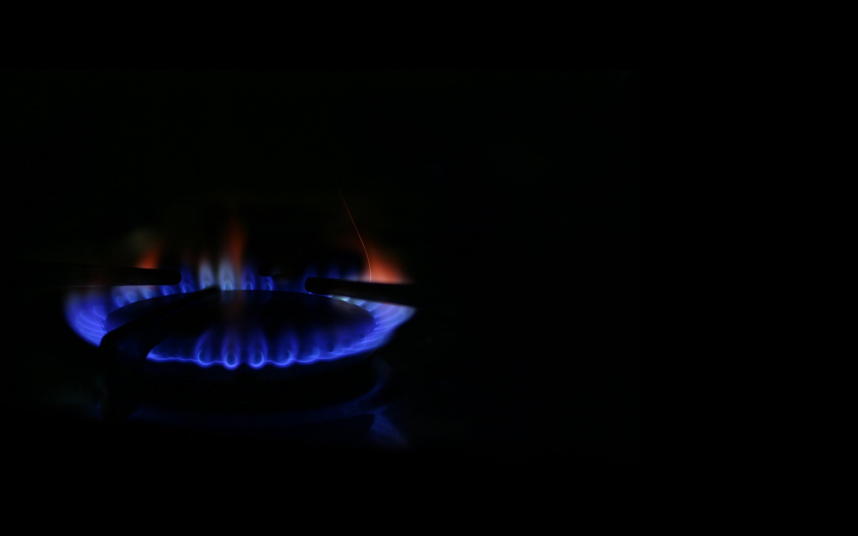 Gas burner on a black background. Blue and red flames