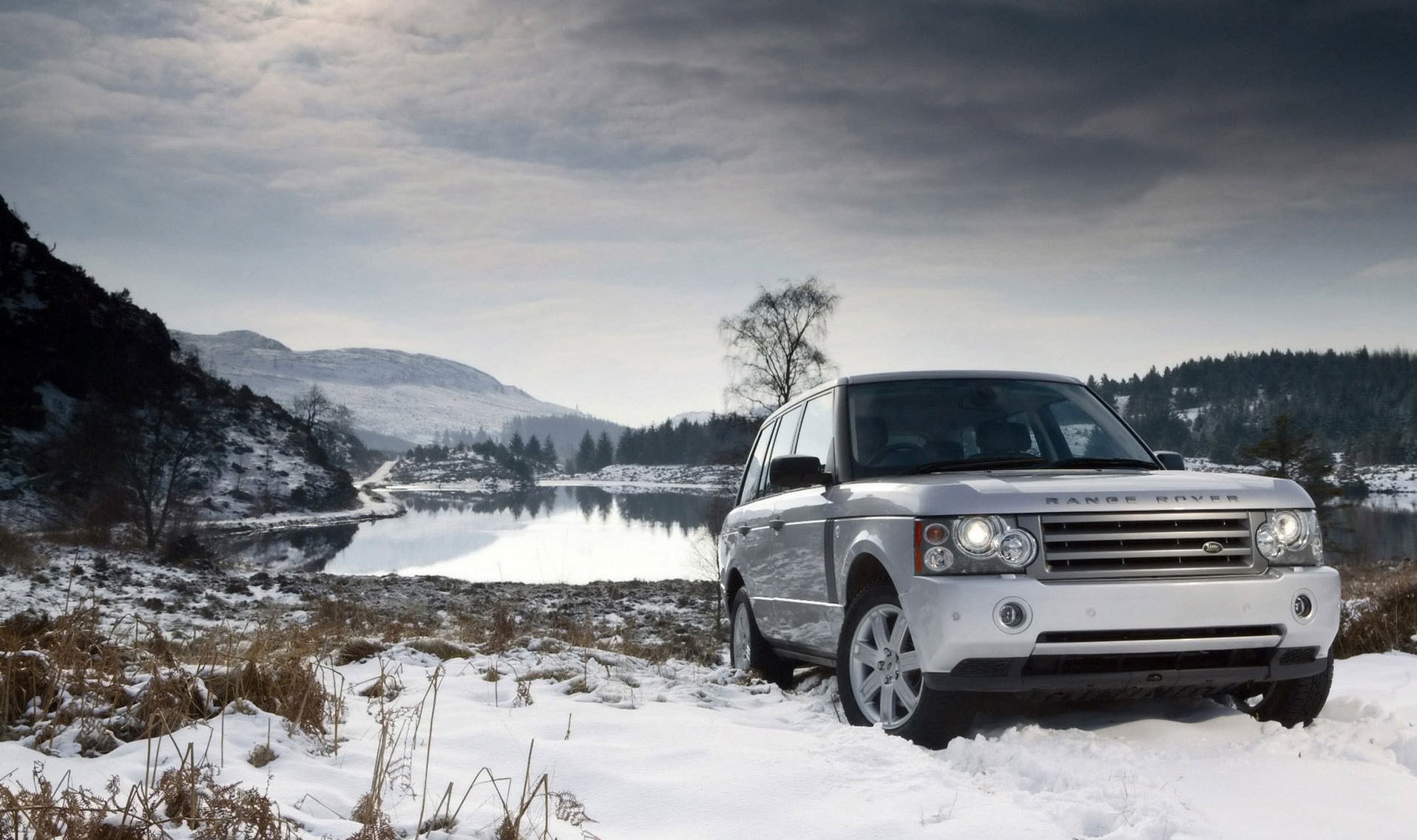 White land rover in the winter landscape near the lake
