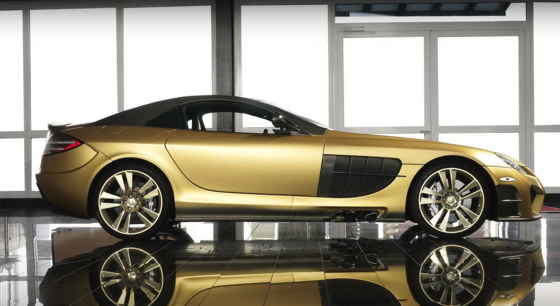 Golden mansory mercedes-benz on the background of panoramic windows. Luxury car in gold color