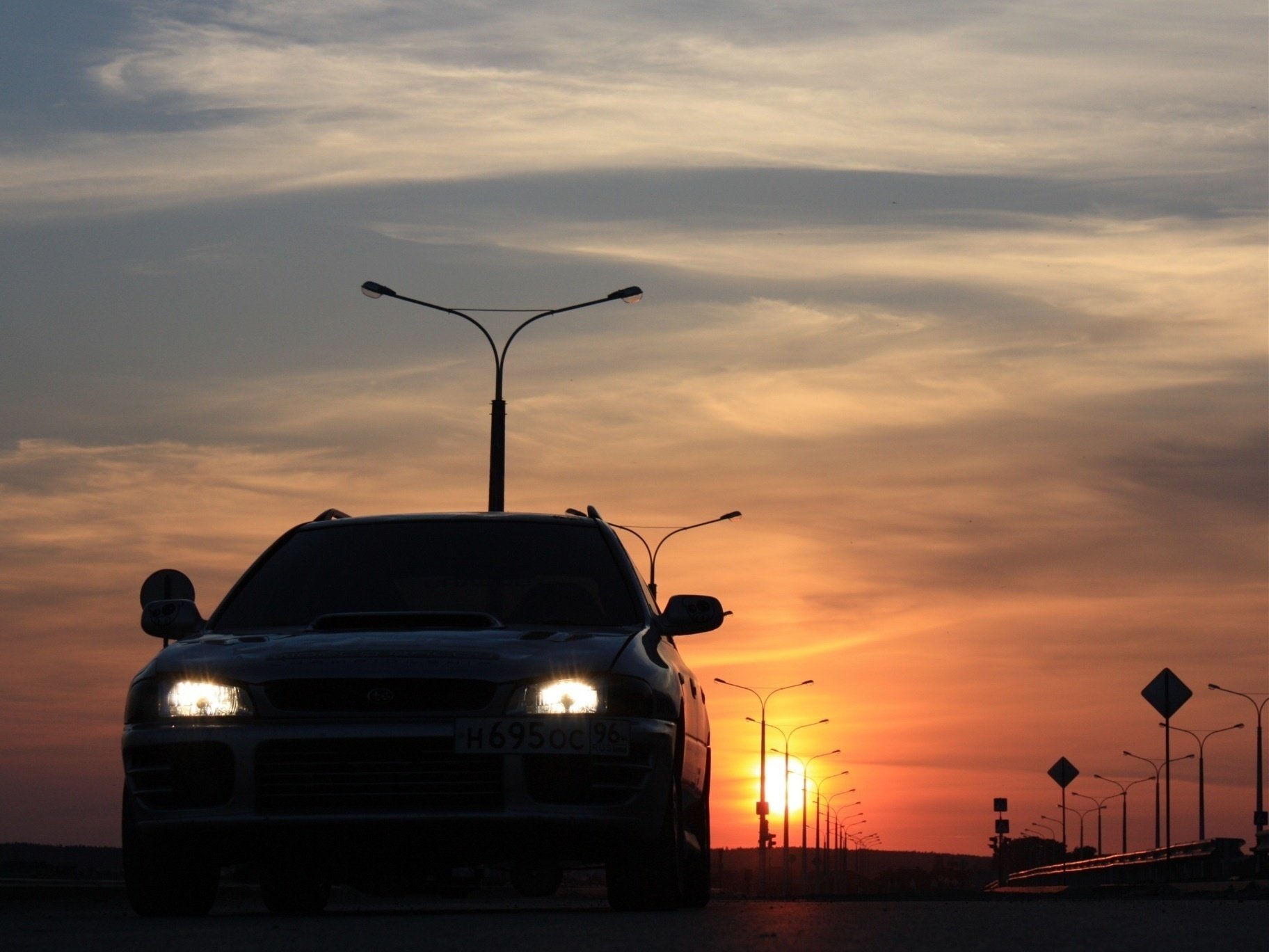 Headlights of a passenger car at sunset