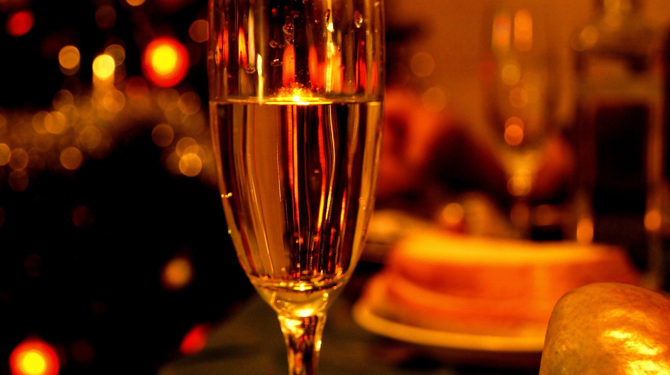 A glass of champagne on the festive table in the evening light