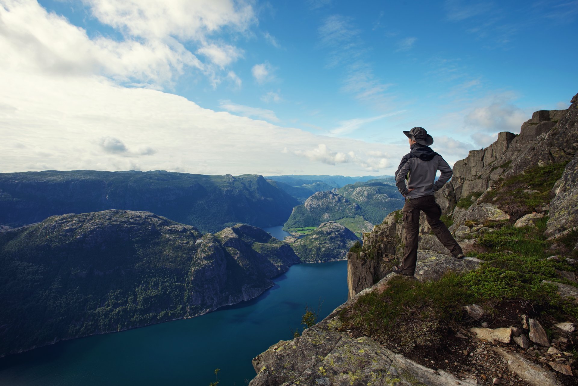 lonely guy man traveler hiker fjord panorama sea sky mountain clouds nature alone men traveller tourist fjords single
