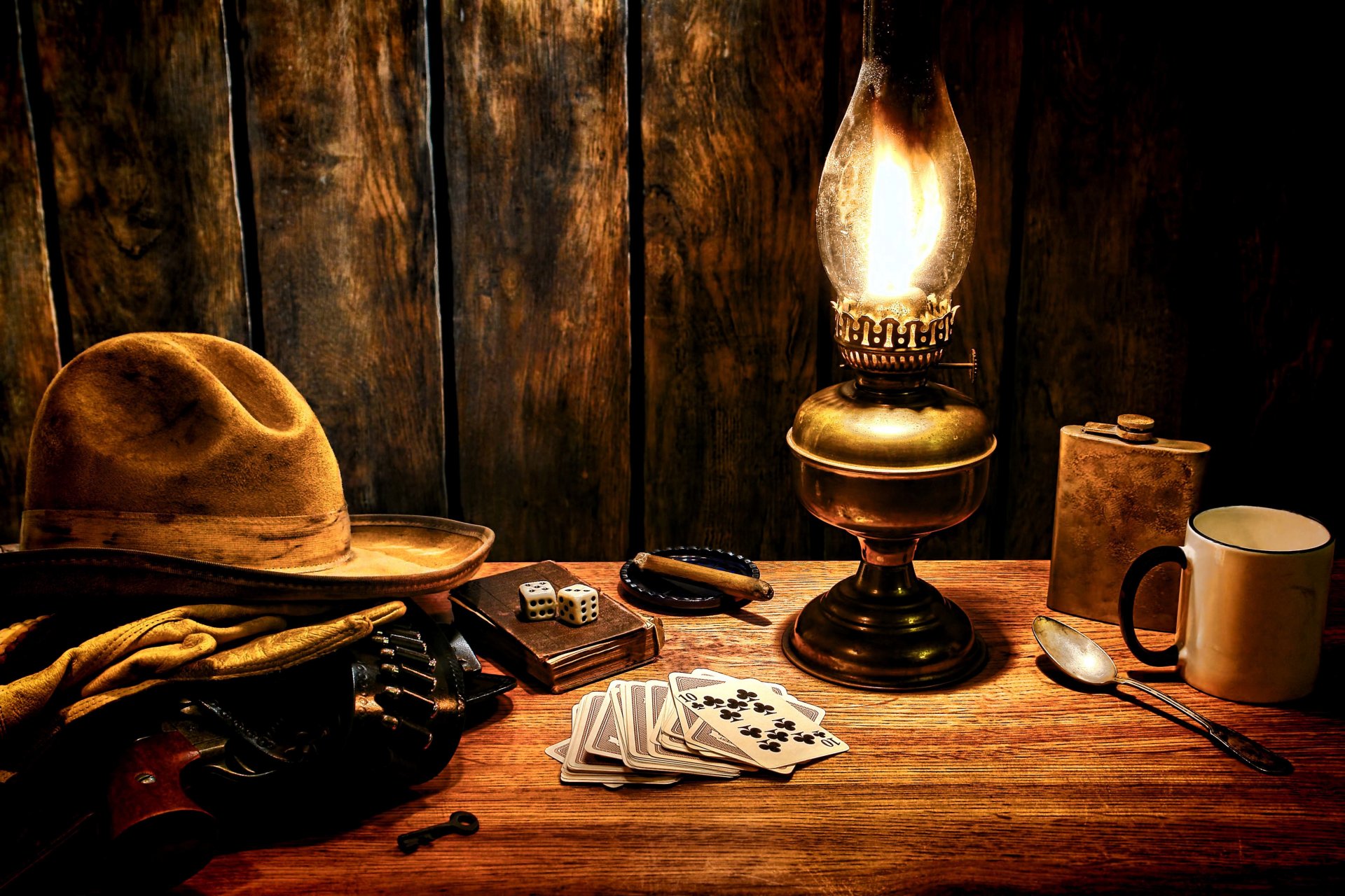 table surface cowboy hat gloves revolver colt bandolier wild west light playing cards bone blocks mug flask key cigar style western wallpaper.