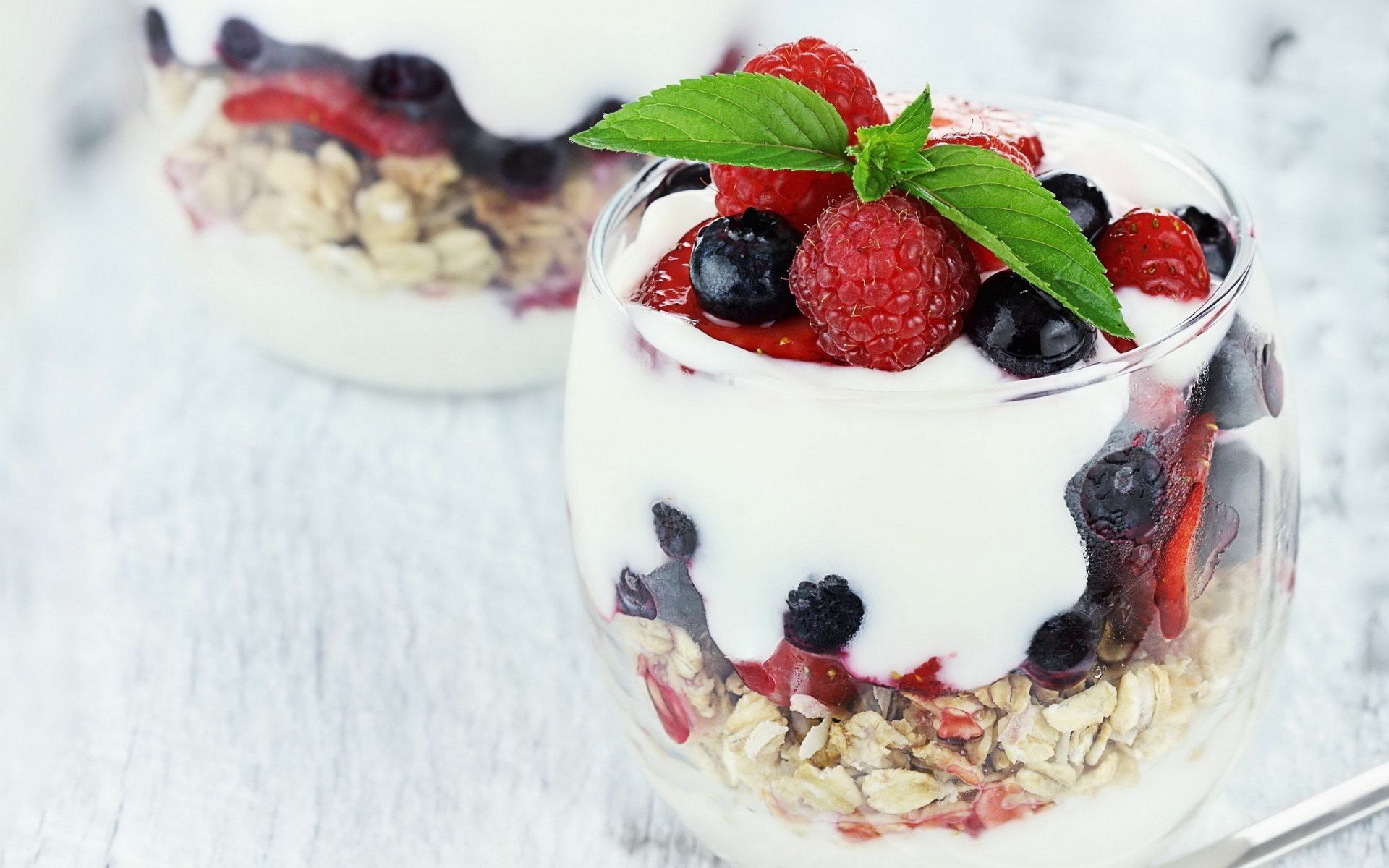 Delicious dessert in a glass of muesli , ice cream and berries
