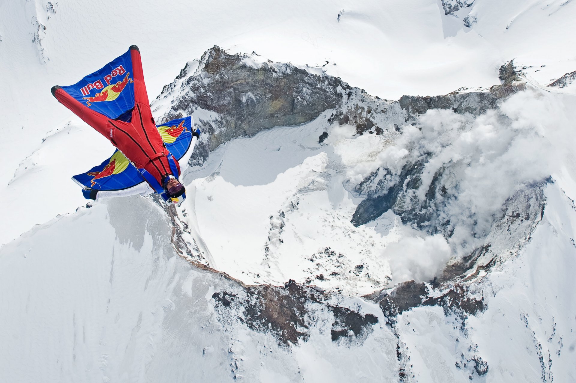 wingsuit pilot fly volcano mountain smoke snow winter trailers parachute red bull extreme sports