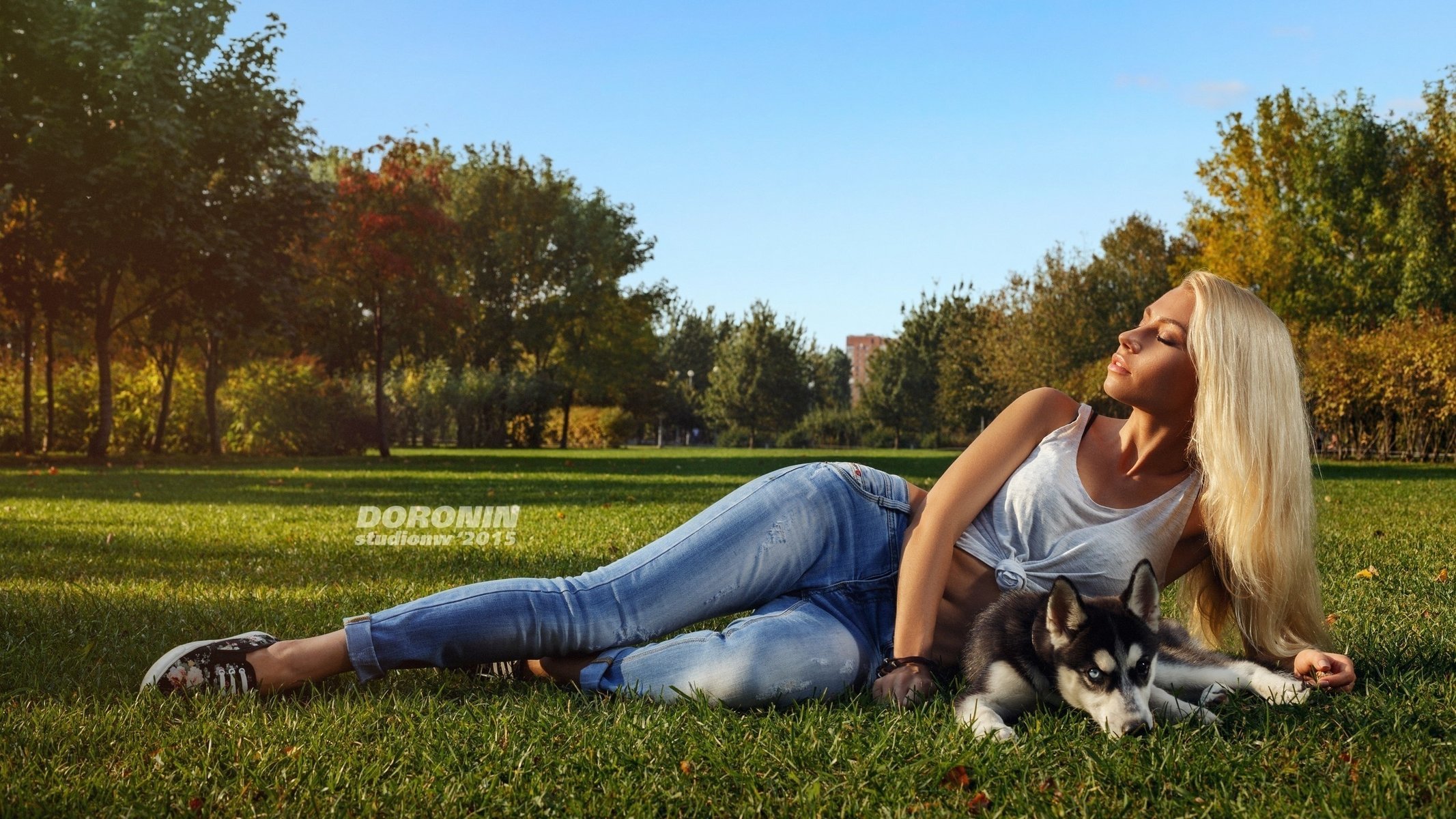 Blonde with husky lying in nature