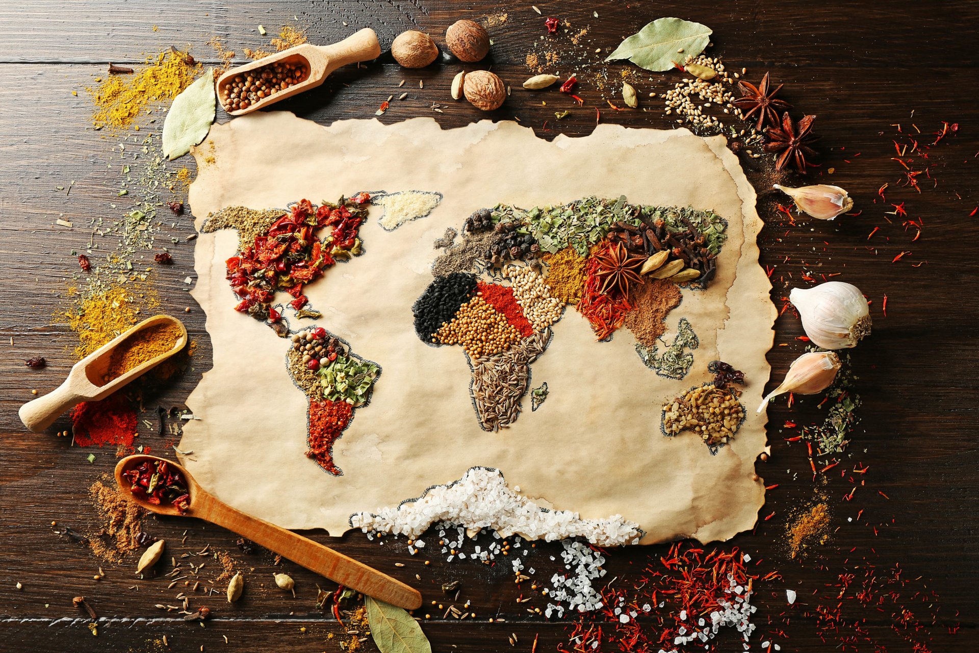 food spices surface map of the world continents seasonings nutmeg red black pepper curry carnation coarse salt bay leaf anise garlic saffron thyme good idea creative positive table yum-yum blur bokeh
