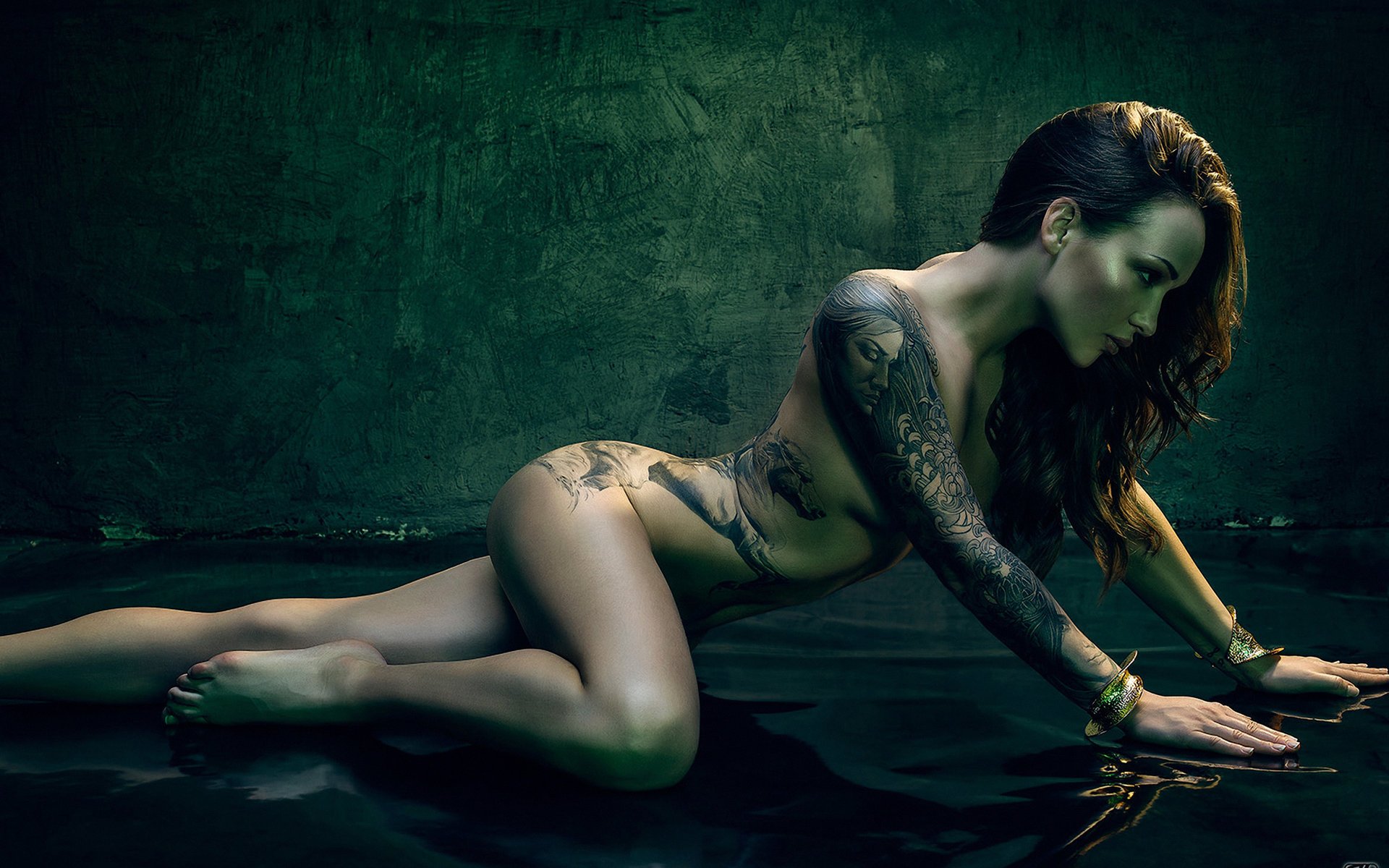 A brown-haired girl with a bracelet and a beautiful tattoo on a turquoise background