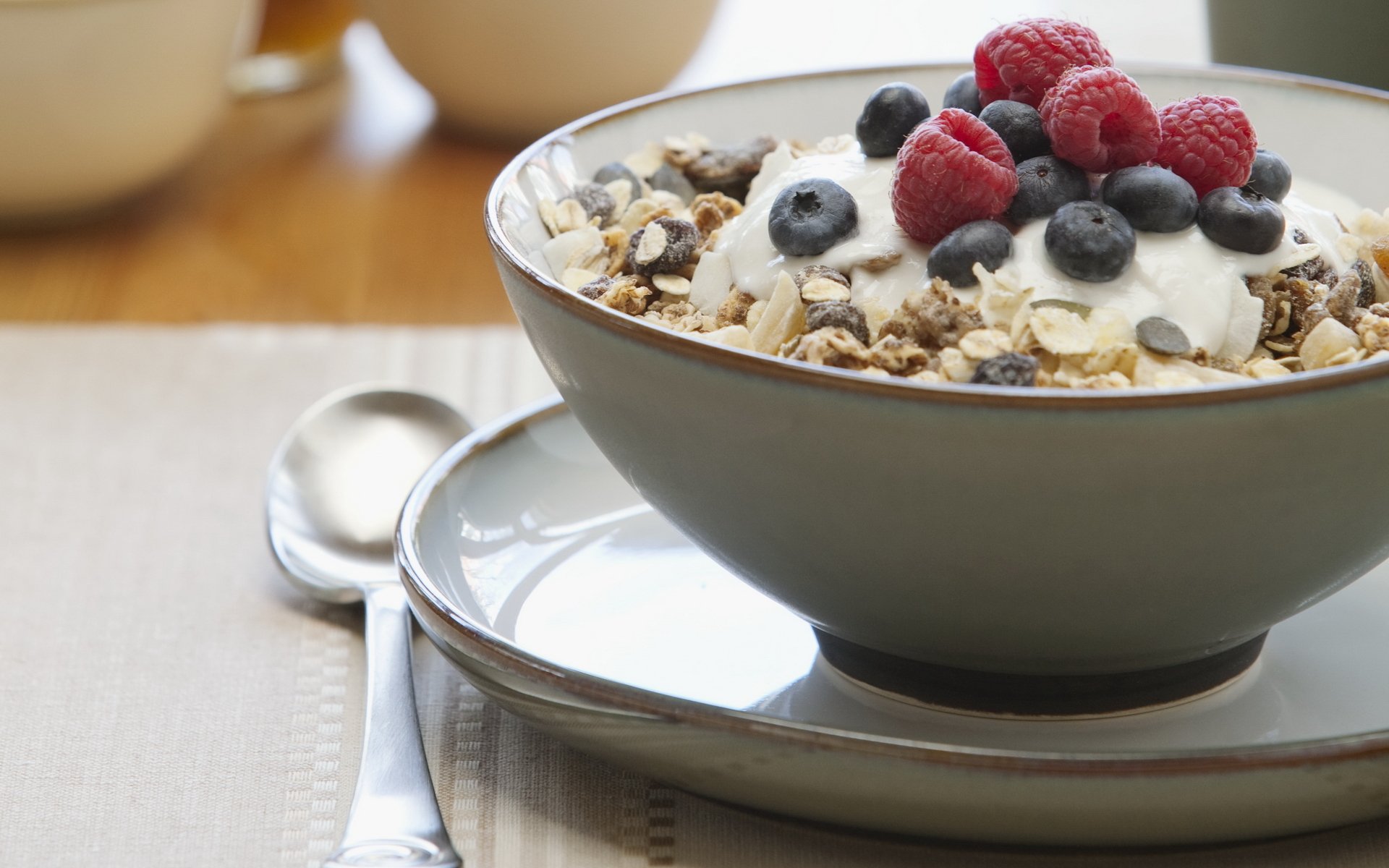 food sweet breakfast muesli raspberries blueberries raisins dish spoon