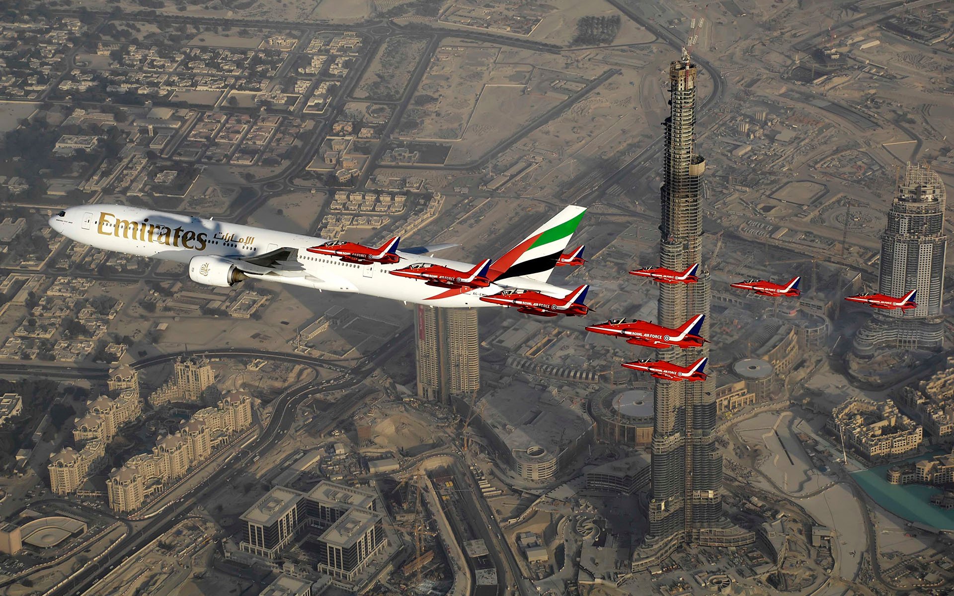 plane passenger airliner boeing 777 airlines emirates family wide aircraft to large length sky on dubai accompanied by royal military air force hawker siddeley hawk uk