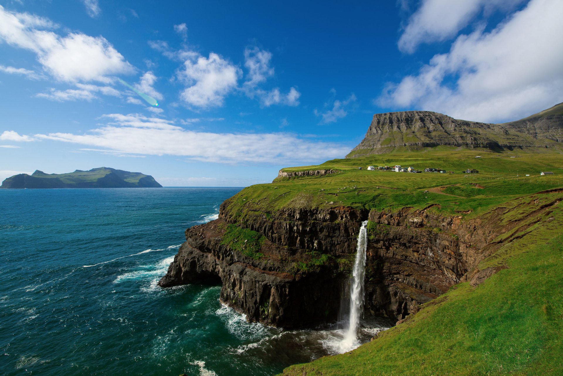 kingdom of denmark faroe islands vága gaasedal atlantic ocean rock on the edge village mountain waterfall sky clouds