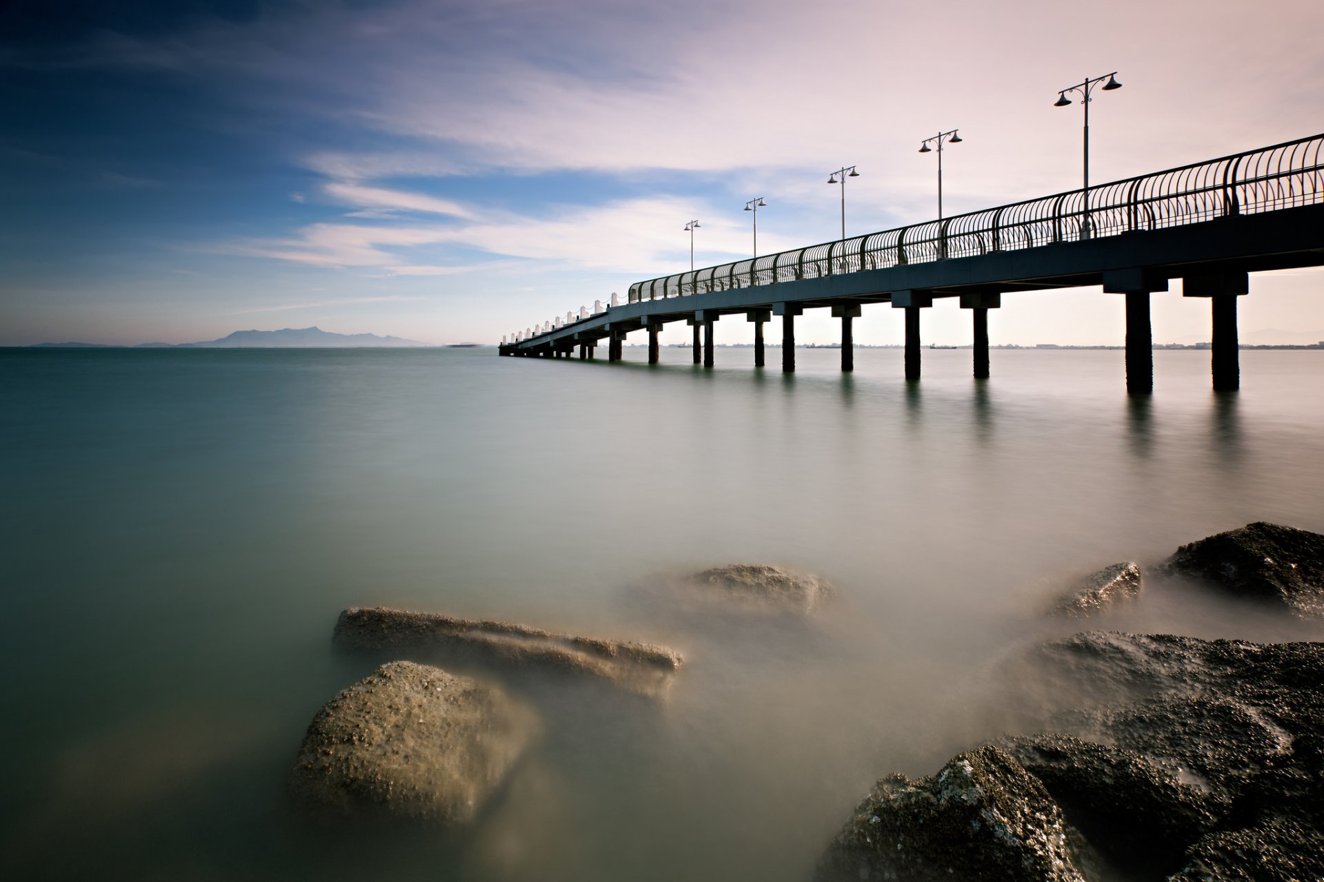 malaysia morning calm sea bridge pier beach stones sky clouds